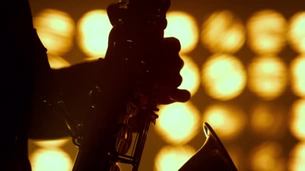 Muzikant handen spelen saxofoon jazz club close-up. Silhouet speler houden sax. — Stockvideo