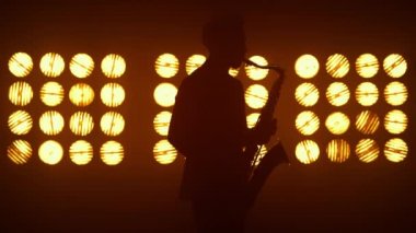 Sahnede bilinmeyen bir caz saksafoncusu sahne alıyor. Modern saksafon tutan oyuncu.