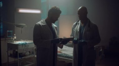 İki doktorun hasta odasında tablet bilgisayarla buluşması..