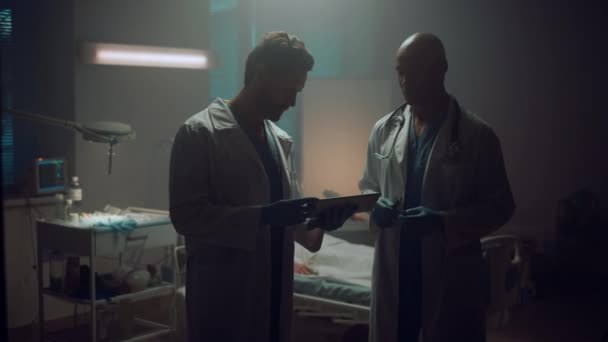 Portrét dva lékaři setkání držící tablet počítač v nemocničním pokoji pacienta. — Stock video