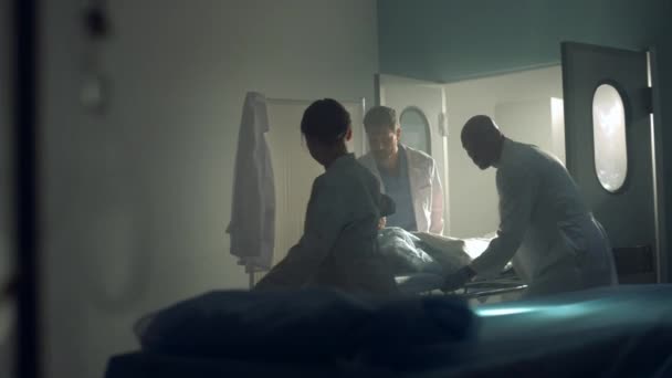 Ärzte bringen Patientin nach erfolgreicher chirurgischer Behandlung in dunkle Krankenhausstation — Stockvideo