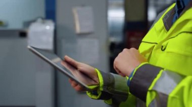 Modern büyük özel tesis deposunda kapalı eller tablet bilgisayarı tutuyor..