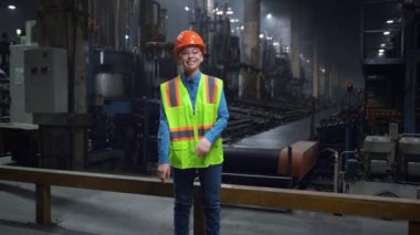 Kadın tamirci el ele tutuşup özel bir tesis kurarken kameraya bakıyor..