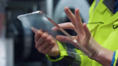 Üretim şirketinde cam tablet bilgisayarı daktilo eden denetimci eller.