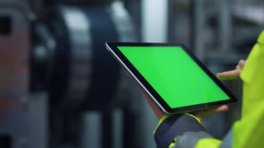Eller modern üretim fabrikasında yeşil ekran tablet bilgisayarı kaydırıyor.