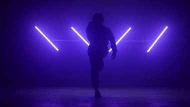 Dansçı hip hop gece kulübünde çalıyor. Siluet B-boy çevik hareketler yapıyor.