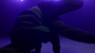 Dansçı adam gece kulübünde break dans yapıyor. Çevik adam vücut çeviriyor. 