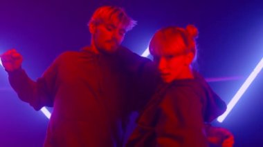 Mor ötesi ışıkta serbest dans eden şık bir çift. Yakın plan.. 