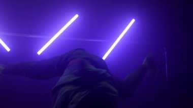 Havalı break dansçı, kulüpte hiphop hareketleri gösteriyor. Siluet dansçısı..