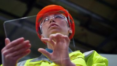 Fabrikadaki saydam tablet bilgisayar üzerinde çalışan kadın uzmanlar..