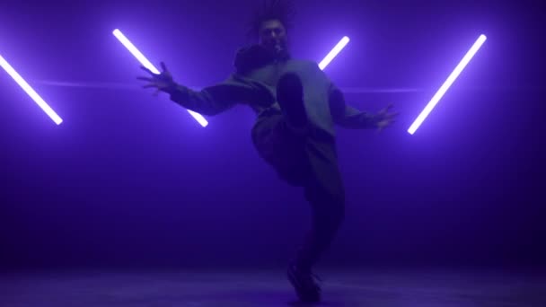 Hiphop wykonuje sztuczki na scenie. Aktywny człowiek freestyle w ultrafiolecie. — Wideo stockowe