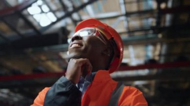 Siyah saç mühendisi modern üretim sanayi deposunun çatısını arıyor..