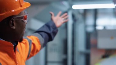 Üniformalı mühendis imalat şirketinde bilinmeyen bir uzmanla konuşuyor.