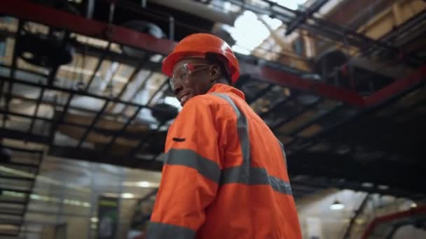 Superviseur joyeux regardant la caméra à l'entrepôt moderne énorme installation industrielle. — Video