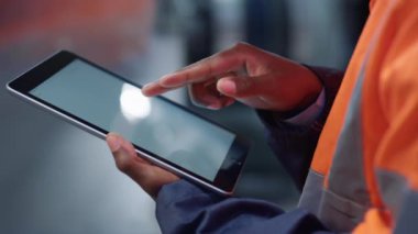 Fabrika kapanışında eller tablet ekranı kaydırıyor. Modern teknoloji