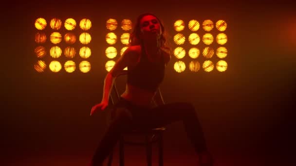 Woman making erotic twine sitting on chair nightclub. Girl performing dance. — Stock Video