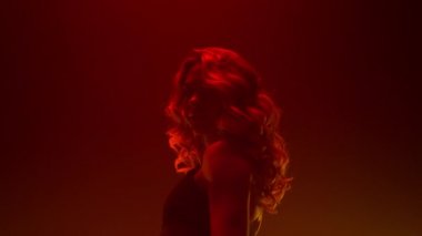 Striptiz kulübünde dans gösterisi yapan sarışın. Seksi dansçı kız el kaldırıyor.