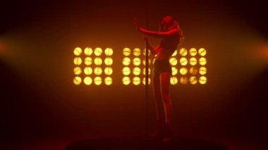 Striptiz kulübünde erotik dans gösteren seksi sarışın. Poledans eden seksi kadın..