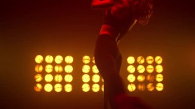 Gece kulübü sahnesinde akrobatik elementler dansı yapan kız dansçı..