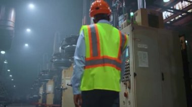 Depoda devasa metal inşaat işlerini inceleyen profesyonel bir yönetici..