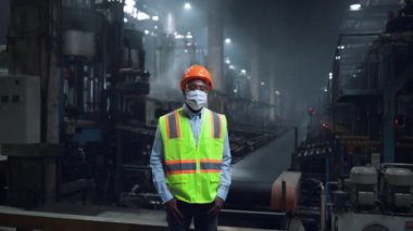 Dijital enerji üretim fabrikasına bakan maskeli bir yönetici..