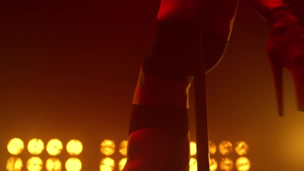 Жінка звисає догори ногами на стовпі, виступаючи в приміщенні. Сексуальна дівчина танцює забруднення — стокове відео