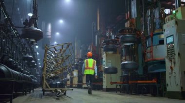 Tanımlanamayan işçi, devasa modern manufature deposunda yürüyor..