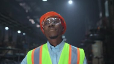 Siyah saçlı profesyonel lastik üretim fabrikasında yürüyor..