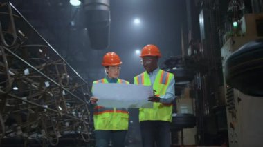 Denetmen ortaklar büyük bir depoda güvenlik üniforması giymeyi tartışıyorlar..