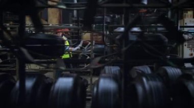 Modern lastik fabrikasında yürüyen profesyonel denetçi çift. Endüstriyel kavram