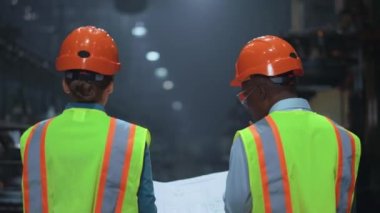 Özel fabrika deposunda yürüyen çok ırklı profesyonel yöneticiler..