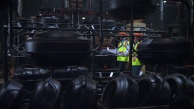 Yönetici meslektaşlar modern büyük özel depoda proje çalışmalarını tartışıyor.