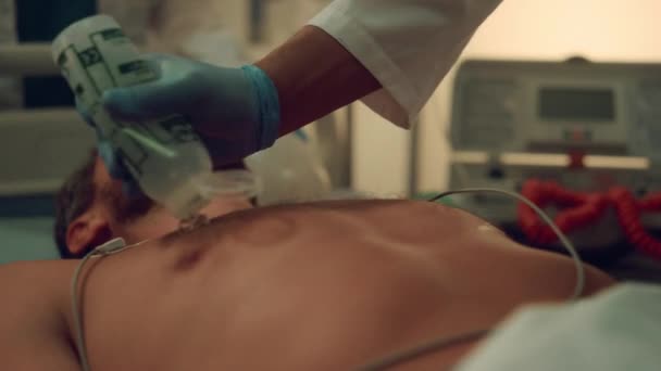 Doktor hastanenin acil servisinde defibrilasyon yapan hastayı muayene ediyor.. — Stok video
