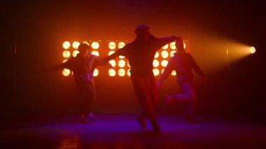 Hiphop sanatçıları gece kulübünde ritmik hareket ediyorlar. B-boys grubu serbest dans ediyor.