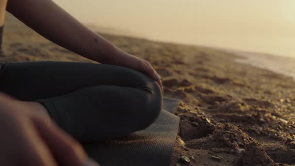 Kobieta ciało siedzi lotosu pozować na plaży piasku z bliska. Slim dziewczyna medytuje. — Wideo stockowe