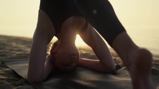 Yogi femme debout tête pratiquant shirshasana soirée d'été gros plan. — Video