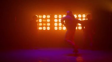 Hiphop ekibi yetenek yarışmasında profesyonel olarak dans ediyor. Üç erkek breakdance yapıyor.