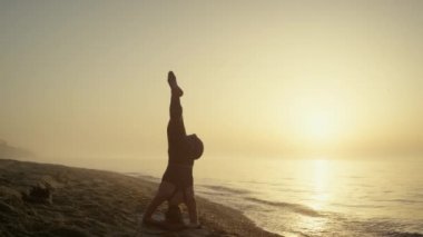 Güzel bir kız, yaz akşamı kafasının üstünde sicim eğitiyor. Egzersiz yapan kadın.