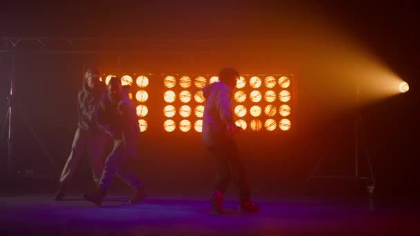 Silhouettes three talented hiphopers performing on stage. Men dancing freestyle. — Stock Video