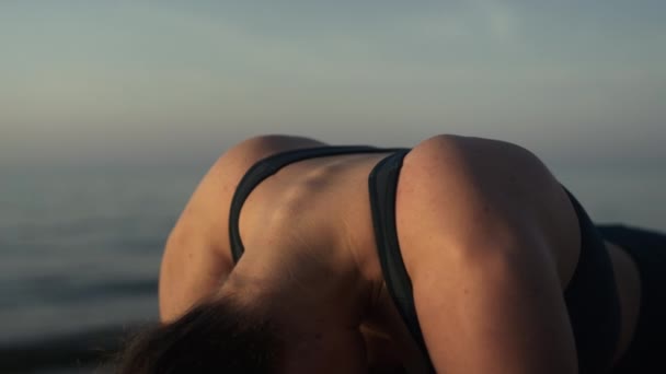 Chica relajada doblando cuello de pie tablón pose en primer plano de la playa. Mujer estiramiento — Vídeos de Stock