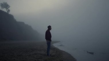 Sahilde müzik dinleyen şık bir adam. Adam müzik ritmiyle dans ediyor.