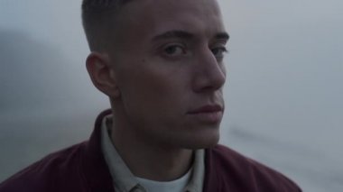 Düşünceli bir adam dışarı bakıyor. Kameraya poz veren ciddi bir adamın portresi.