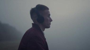 Sahilde dans eden ilham verici bir adam. Kulaklıkla müzik dinleyen adam.