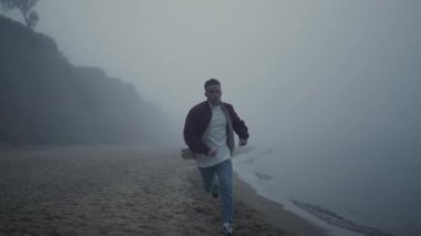 Sabahları sahili yöneten aktif bir adam. Bitkin adam koşudan sonra duruyor. 