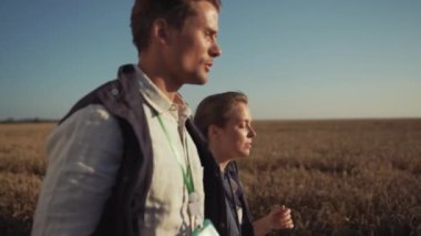 Buğday tarlasında yürüyen iki çiftçi. Çiftlikteki tarım mühendisleri.