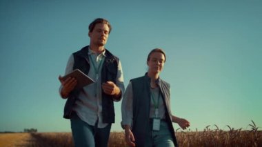 Tarım mühendisleri altın güneş ışığında yürüyorlar. Modern tarım endüstrisi