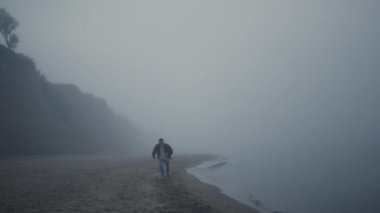 Sabahları kumsalda koşan sıradan bir adam. Genç adam deniz kıyısında hızla ilerliyor.