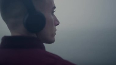 Düşünceli adam müzik kulaklıkları dinliyor. Kafasını müzik ritmine kaptırmış.