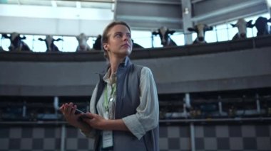 Manager mandıra üretim tesisini kontrol ediyor. Yönetici ped bilgisayarı tutuyor