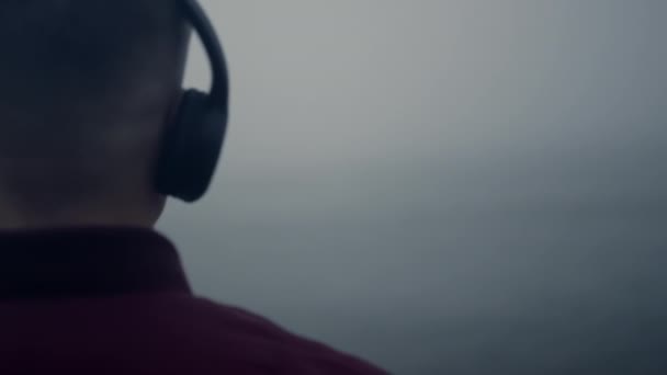 Il tizio con le cuffie ascolta musica in spiaggia. Uomo godendo cuffie canzone musicale — Video Stock
